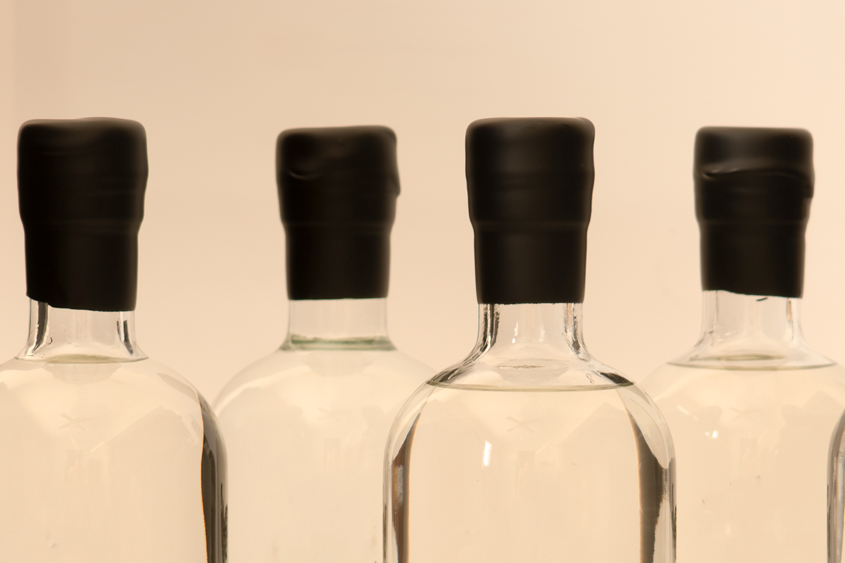 Botellas transparentes con lacre negro en el cuello de la botella