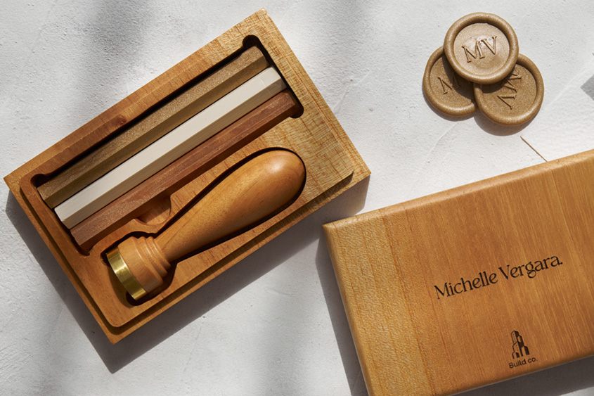 Juego de lacrado clásico, con sello metálico y diseño de iniciales MV, barras de lacre en oro, marfil y cobre, estuche de madera grabado