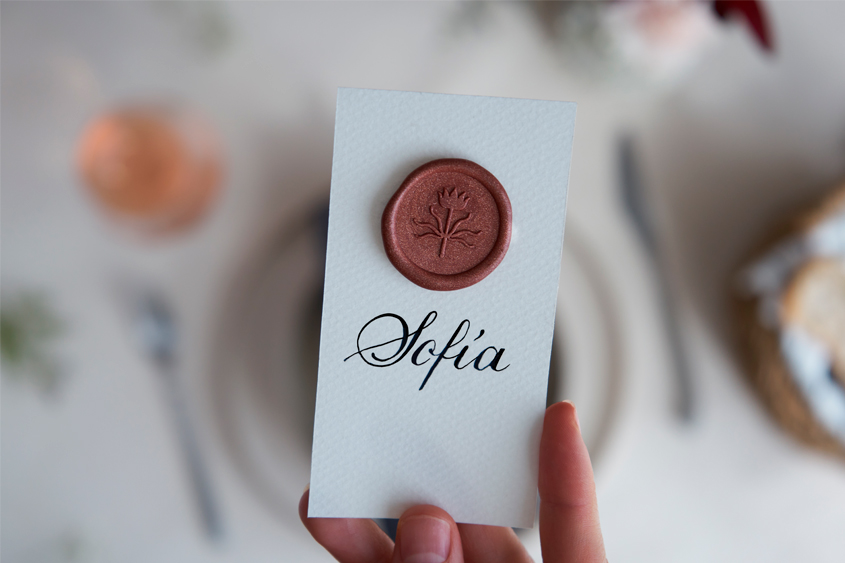 Medallón color canela con el diseño de una flor, puesto sobre una tarjeta con el nombre de Sofía escrito en caligrafía 