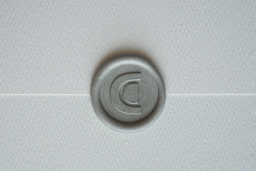 Sobre blanco lacrado con un sello de logo CF en color plata