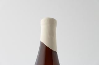 Botella de cerveza con lacre para botella color marfil en el cuello de la botella dejando en diagonal el lacre