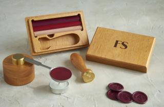 Set de lacrado con estuche grabado con iniciales FS, barras de lacre en tinto, rojo y rosa, fundidor mini y medallones tintos