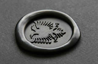 Medallón de lacre negro con sello de águila bicéfala